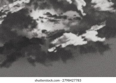 Dramatic monochrome clouds drifting across a stormy sky with high grain texture