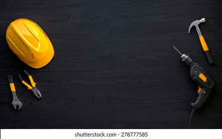 drill, helmet, hammer, pliers and construction tools on black wooden background - Powered by Shutterstock