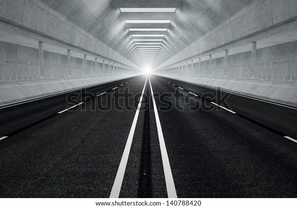 Driving through an underground car\
tunnel. Daylight seeps in through the end of the tunnel. May\
represent travel, speed, transportation or urban\
communication.