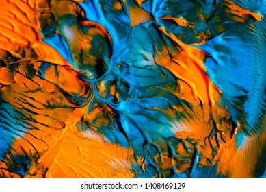 Dynamic fluid color paint splashes background. Blue and orange mixed liquid backdrop. Abstract marbling effect. Dynamic fluid
