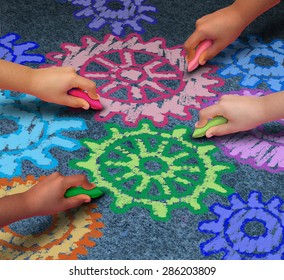 Education Concept As A Diverse Community Of Children Working Together In Friendship Drawing Connected Gears And Cog Wheels With Chalk As A Symbol For The Success Of Learning With A School Program.