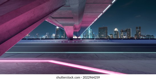 Leere Asphaltstraße unter der Brücke während der Nacht mit schönem Skyline-Hintergrund der Stadt . 3D-Rendering