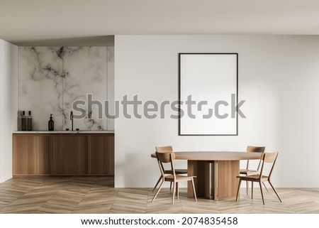 Empty frame mockup in beige dining room with round table and minimalist marble kitchen on background. Parquet floor. 3d rendering