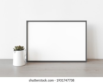 Empty Grey Rectangular Horizontal Frame Stands On Light Wood Table Against Wall. Mockup Of Poster Frame Close Up In Home Interior With Succulent Plant, 3D Illustration