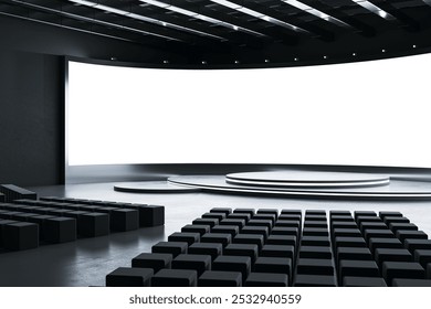 Empty modern conference hall with black seats, curved stage, and a large blank screen in the front. Ideal for presentations or exhibitions. 3D Rendering - Powered by Shutterstock