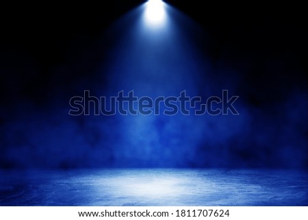 Empty space of Studio dark room with blue lighting effect and fog on concrete floor in black background. 