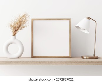 Empty Square Frame Mockup In Warm Neutral Minimalist Interior With Dried Pampas Grass, Trendy Vase And Brass Desk Lamp On Wooden Beige Brown Shelf On White Wall Background. Illustration, 3d Rendering