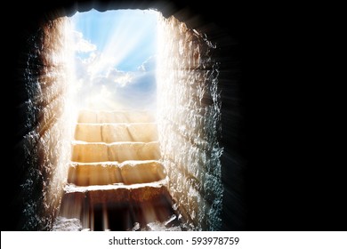 Empty Tomb - Easter Resurrection Of Jesus Christ With Stone Rocky Cave, Bright Sky And Sun Light Beams Or Rays Bursting