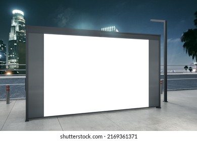 Empty White Bus Stop Billboard On Blurry Night City Backdrop. Commercial And Ad Concept. Mock Up, 3D Rendering