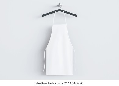 Empty white kitchen apron on hangers. Light background. Chef and cooking concept. Mock up place. 3D Rendering