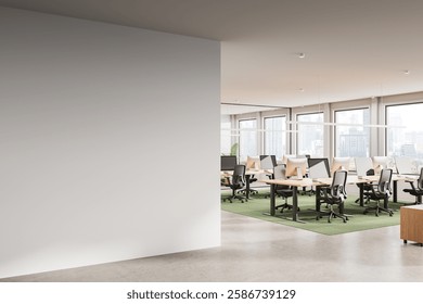 Empty white wall for poster or artwork display in a bright open-plan office with desks, chairs, and computers. Large windows show a cityscape view. 3D Rendering
