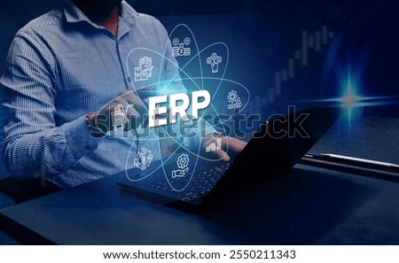ERP Cloud System Software Automation: A businessman analyzes Enterprise Resource Planning (ERP) software or applications on a virtual screen using his laptop.