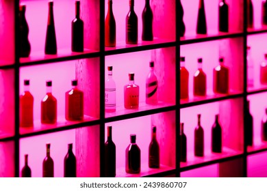 An eye-catching setup featuring a variety of bottles, each backlit by a deep pink hue, arranged neatly on shelves, showcasing a blend of modernity and aesthetic appeal.