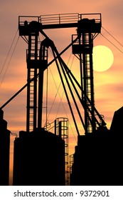 Factory structure silhouetted against  sunset.  Sky added in PS