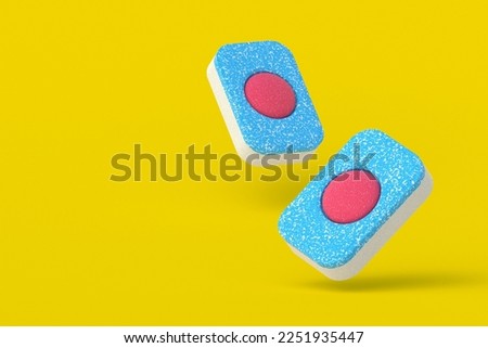 Falling dishwasher detergent tablets on yellow background. Copy space. 3d render