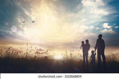 The family life journey concept: Father, mother and two son over meadow sunset background - Powered by Shutterstock