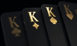 A Fanned Out Suit Of Four Black King Casino Playing Cards With Gold Markings On A Dark Classy Background - 3D Render