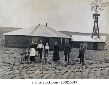 A Farm Family Standing In Front Of Sod House And Windmill. Coburg, Nebraska 1885