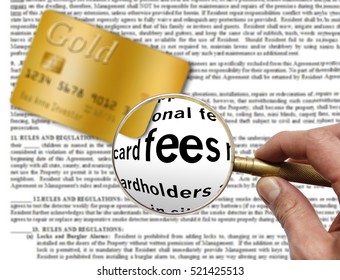 Fees In A Credit Card Agreement Are Shown Through A Magnifying Glass.