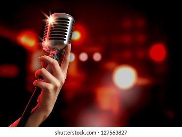 Female hand holding a single retro microphone against colourful background - Powered by Shutterstock