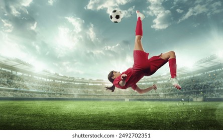 Female soccer player in red performs bicycle kick on stadium field. Stadium with spectators. Cinematic shot. Victory. Concept of sport, championship, action, team game, tournament. Ad - Powered by Shutterstock