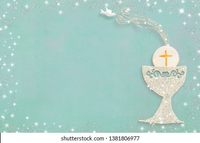 First holy communion invitation card. Silver chalice on green pastel  tone  paper background with copy space to text and photo. - Shutterstock ID 1381806977