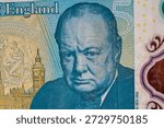 A five-pound note shows the face of Winston Churchill. The note highlights the features and details of the design. It shows England heritage and currency design.