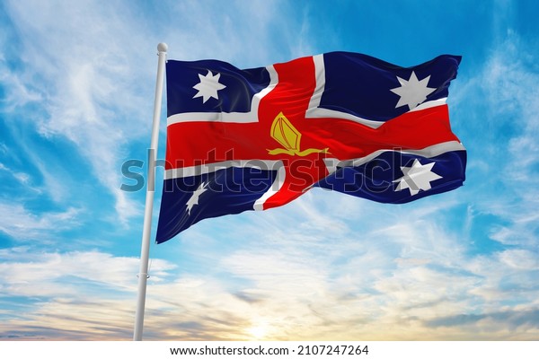 flag\
of Anglican Church of Australia , Australia at cloudy sky\
background on sunset, panoramic view. Australian travel and patriot\
concept. copy space for wide banner. 3d\
illustration