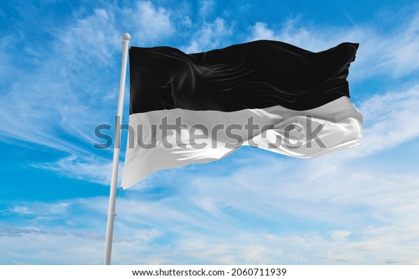 flag of Ulm at cloudy sky background on\
sunset, panoramic view. Federal Republic of Germany. copy space for\
wide banner. 3d\
illustration