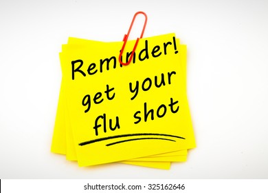 Flu shot reminder against sticky note with red paperclip