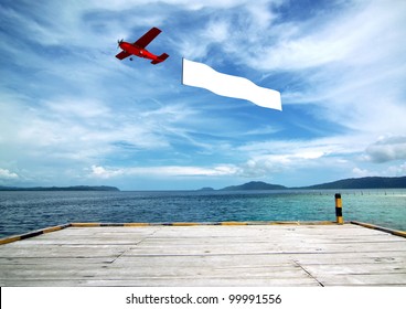 Flying Banner Pulled By Airplane Flying Over A Beautiful Tropical Beach