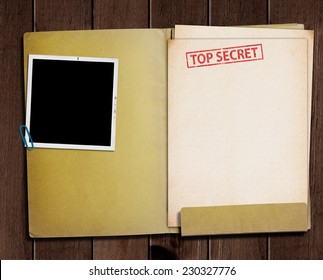 folder with TOP SECRET stamped across the front page and a blank photograph 