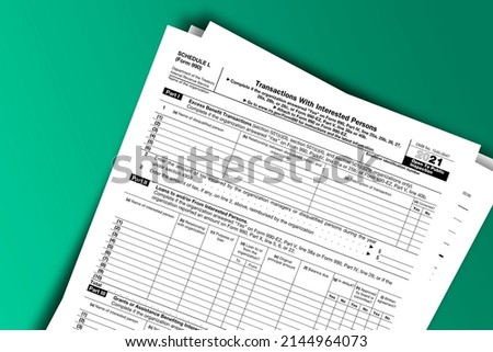 Form 990 or 990-EZ (Sch L) papers. Transactions with Interested Persons. Form 990 or 990-EZ (Sch L) documentation published IRS USA 44207. American tax document on colored Stock foto © 