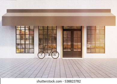 Front View Of A Cafe Entrance With Large Windows  And A Bicycle Near The Door. 3d Rendering. Mock Up. Toned Image