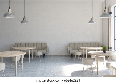 Front view of a modern cafe interior with concrete walls, wooden floor, round tables and chairs and beige sofas near tall windows. 3d rendering mock up
