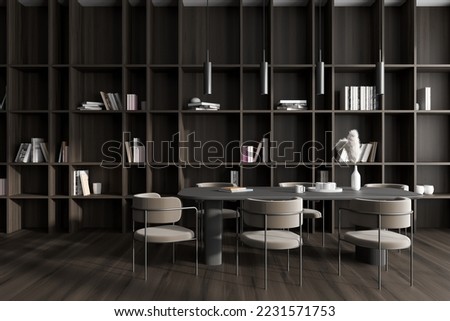 Front view on dark dining room interior with dining table, armchairs, books on shelves, large bookshelf, brown wall, lamp, oak wooden floor. Concept of minimalist design. 3d rendering