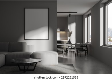 Front View On Modern Dark Studio Room Interior With Empty White Poster, Dining Table, Window, Chairs, Sofa, Grey Walls, Concrete Floor, Fridge. Concept Of Minimalist Design. Mock Up. 3d Rendering