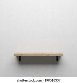 A front view of a regular cleared wooden shelf with brackets on a white wall  - Shutterstock ID 199018337