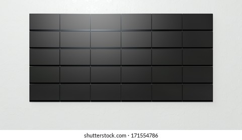 A front view of a wall 30 stacked flat screen televisions mounted on a light colored wall background