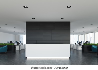 Front View Of A White Reception Desk Standing In An Open Space Office Environment With A Black Wall, Rows Of Computer Tables And Loft Windows. 3d Rendering Mock Up