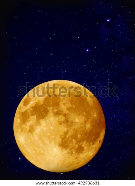 Full\
yellow moon with star at dark night sky\
background