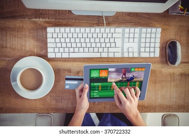 Gambling app screen against cropped image of woman using tablet - Powered by Shutterstock