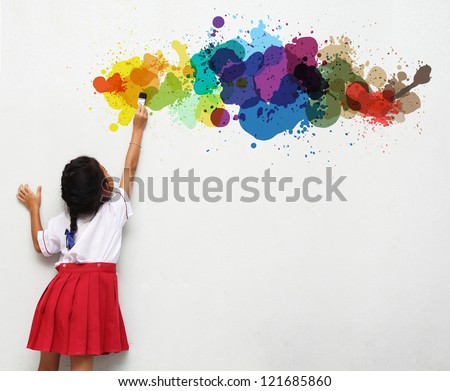 girl holding a paint brush painting on a white wall