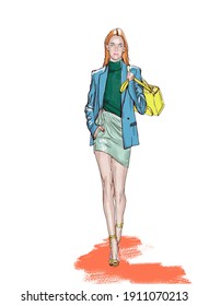 Girl Walks With Bag. Fashion Model In Blue Blazer And Green Skirt With Yellow Bag Walks Along The Runway. Picture For Poster And Fashion Bloggers. 