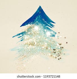 Glitter and glittering stars on abstract blue watercolor Christmas tree
in vintage nostalgic colors.