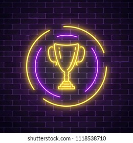 Glowing Neon Sign With Award Cup In Round Frame On Dark Brick Wall Background. Winner Cup Honorary Trophy