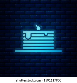 Glowing neon Stack of pancakes icon isolated on brick wall background. Baking with syrup and cherry. Breakfast concept.  