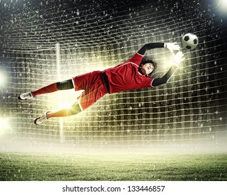 Goalkeeper catches the ball . At the stadium, in the spotlight. - Powered by Shutterstock