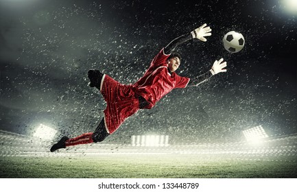 Goalkeeper catches the ball . At the stadium, in the spotlight. - Powered by Shutterstock