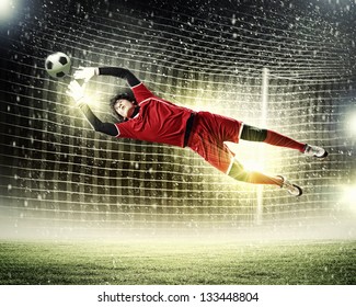 Goalkeeper catches the ball . At the stadium, in the spotlight. - Powered by Shutterstock